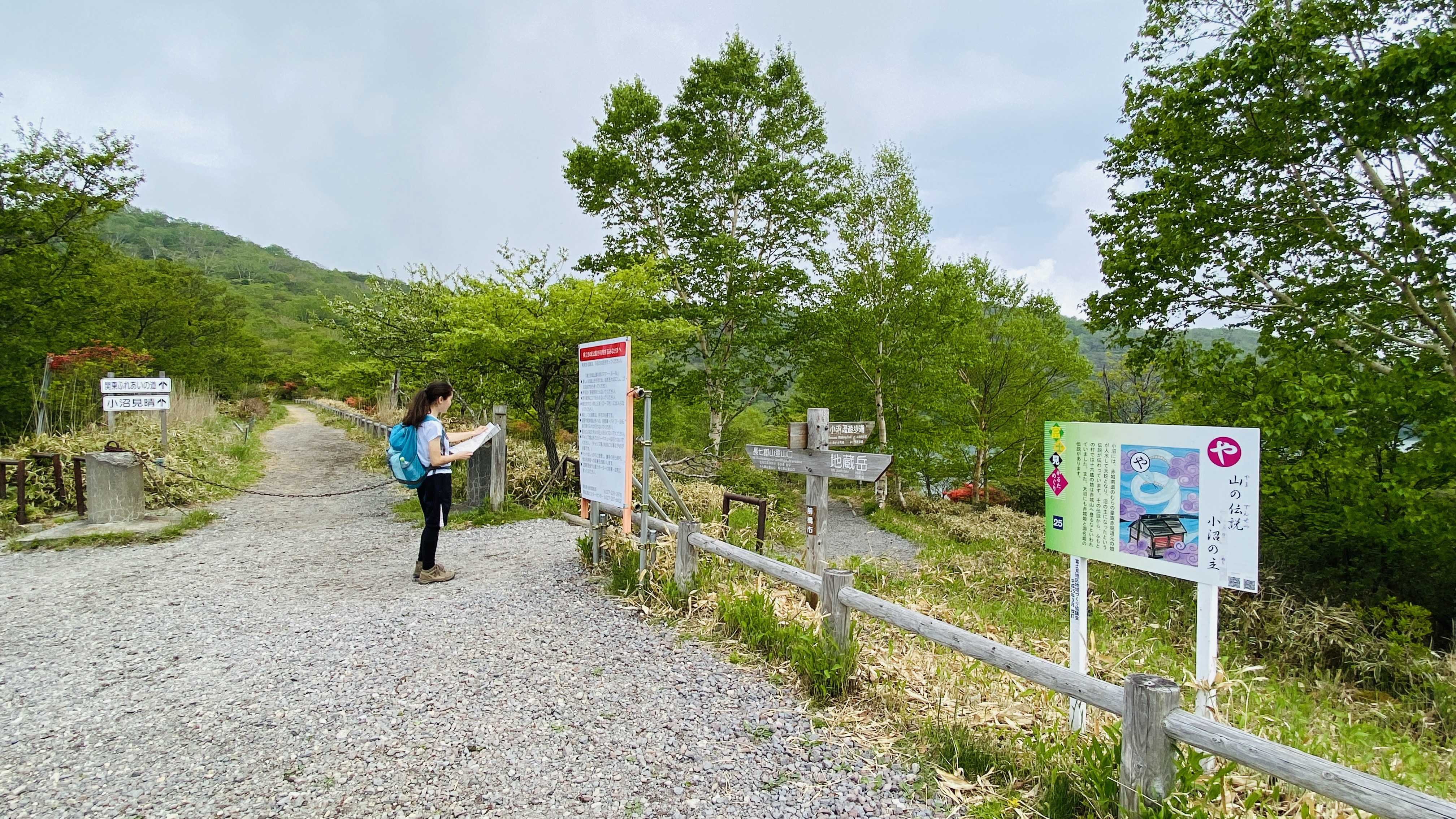 A hiker looks at a map next to two different trails