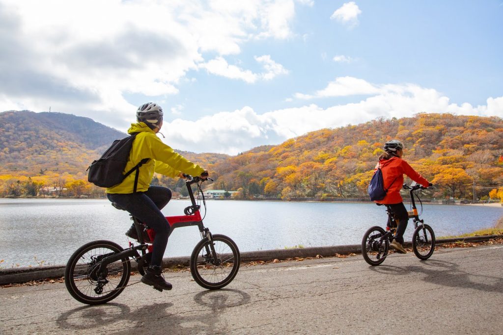 Cyclists riding e-bikes with a lake in the background