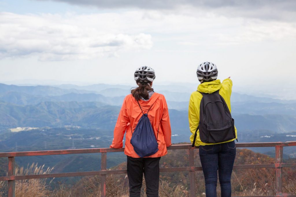 People looking out at mountains from a scenic viewpoint