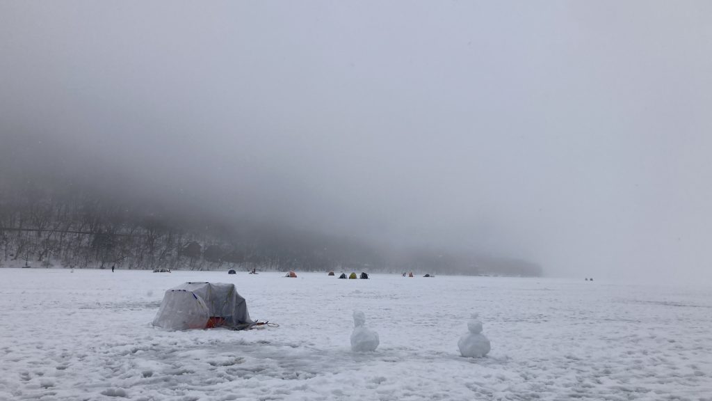 A misty frozen landscape with snowmen