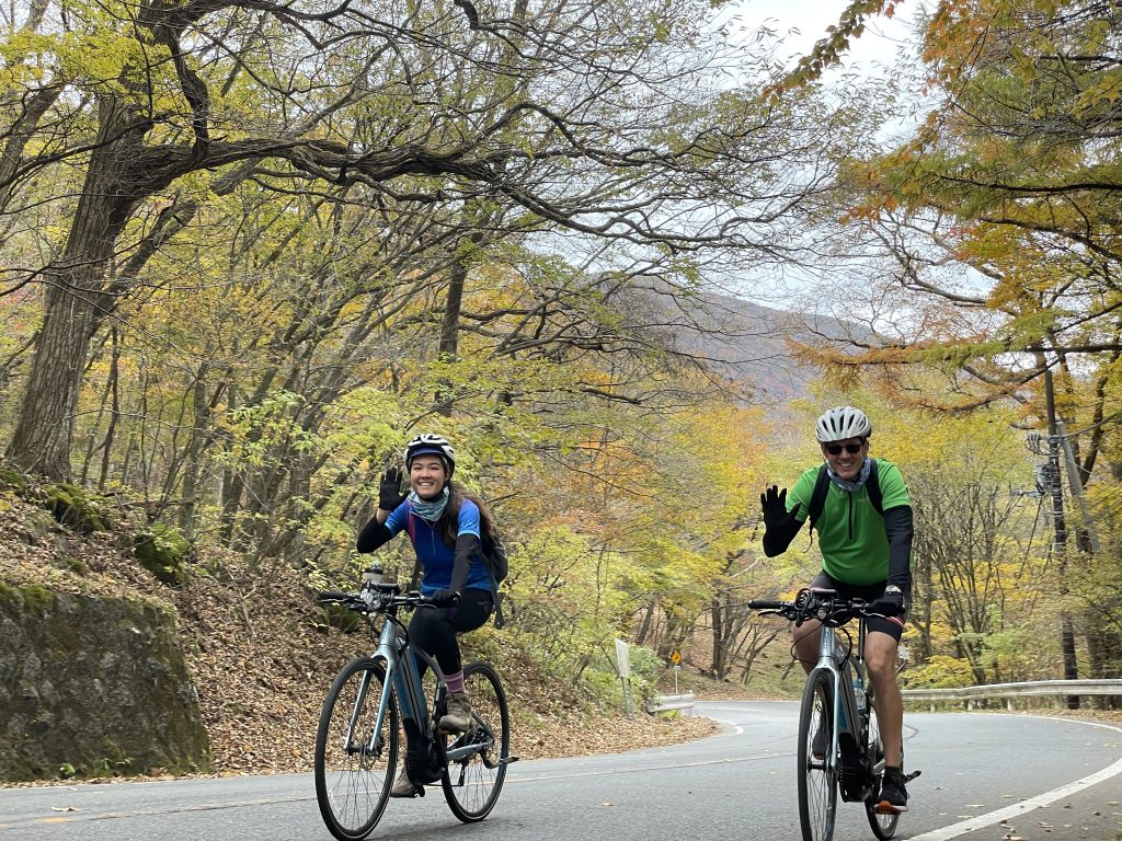 Two cyclists waving at the camera