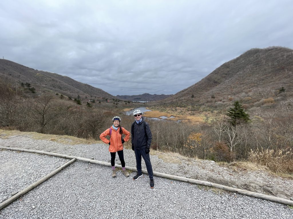 Two people standing proudly in front of a volcano crater viewpoint