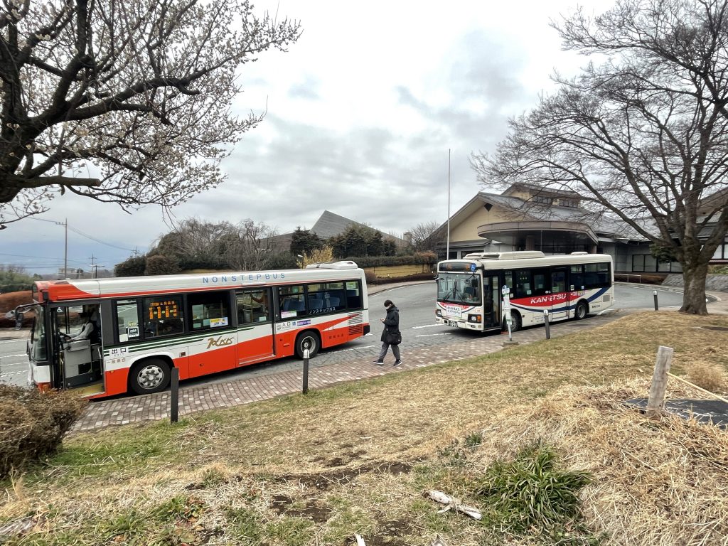 Two buses stopped at a bus station