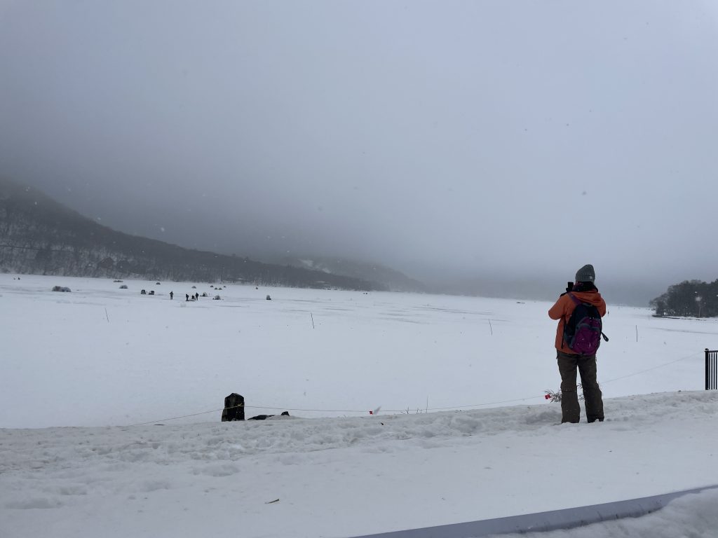 A person taking a picture of a misty winter landscape